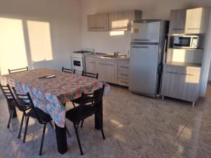 een keuken met een tafel met stoelen en een koelkast bij Mi Descanso in Balneario Claromecó