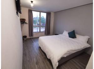 a bedroom with a white bed and a window at Hotel O ZZZ in Kuah