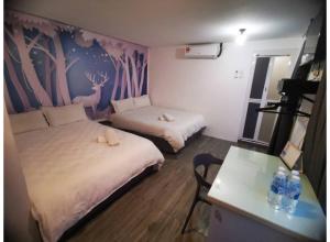 a room with two beds and a table with a table at Hotel O ZZZ in Kuah