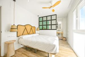 una camera da letto con un letto e un ventilatore a soffitto di Remedios 49 a Vejer de la Frontera