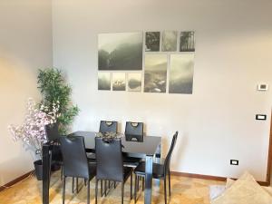 a dining room with a black table and black chairs at Nova milanese design apartment in Nova Milanese