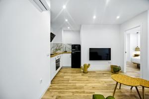 una cucina e un soggiorno con pareti bianche e pavimenti in legno di Remedios 49 a Vejer de la Frontera