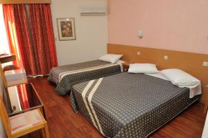 Postel nebo postele na pokoji v ubytování Adonis City Hotel