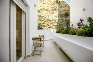 un balcone con tavolo e sedie e una finestra di Remedios 49 a Vejer de la Frontera