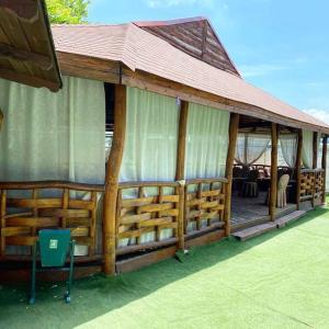a large wooden pavilion with a roof and a chair at VVP Club Hotel in Tiraspol