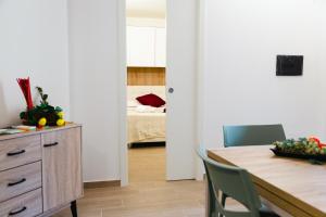 Giù in Calabria B&B - Terrazze Italiane Catanzaro Lido في كاتانزارو ليدو: مطبخ وغرفة طعام مع طاولة وغرفة نوم