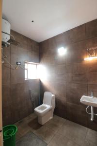 a bathroom with a toilet and a sink at SringeriRooms- Shakthi Homestay in Sringeri