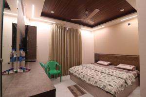 a bedroom with a bed and a green chair at SringeriRooms- Shakthi Homestay in Sringeri +2 photos