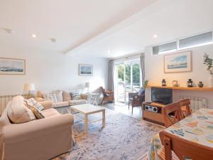 een woonkamer met een bank en een tafel bij Tarquins in Fowey