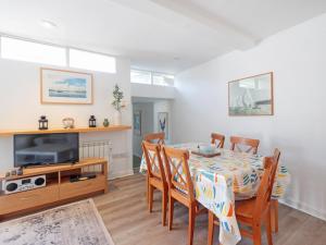 een eetkamer met een tafel en een tv bij Tarquins in Fowey +18 foto's