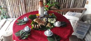 a table with a plate of food on a red table cloth at Tanna Lava View Bungalows in Lénakel