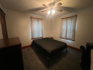 Un dormitorio con una cama y un ventilador de techo. en S and K Properties, en Moline