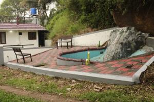 a swimming pool with two chairs sitting on a patio at Valley Homestay in Devikolam