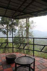 a table and a chair on a patio with a view at Valley Homestay in Devikolam