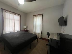 Un dormitorio con una cama y un televisor de pantalla plana. en S and K Properties, en Moline