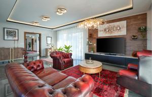a living room with a leather couch and a television at Beautiful Home In Banfi in Štrigova