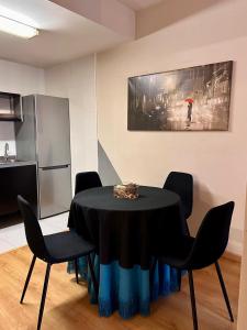 a dining room with a black table and chairs at Estancia en Bernuy SEGOVIA VUT-40-808 in Bernúy de Porreros +5 photos
