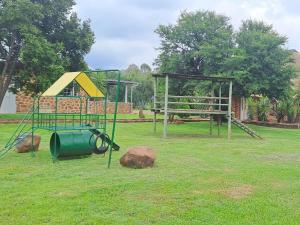 a park with a swing set and a playground at Buck Hill Bush Lodge in Magaliesburg