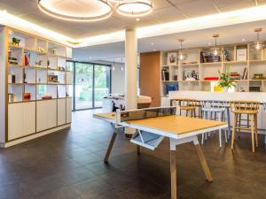 a dining room with a ping pong table and chairs at ibis Genève Petit Lancy in Geneva