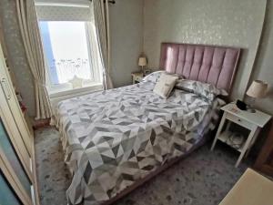 una camera da letto con un letto grande e una finestra di Honeysuckle Cottage a Springside