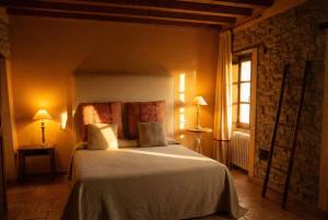 una camera da letto con un letto, due lampade e una finestra di Mulino del Lentino a Nibbiano