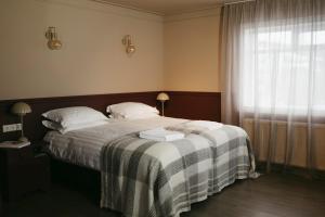 a bedroom with a bed with a checkered blanket at Aurora Farm Hotel in Laugar