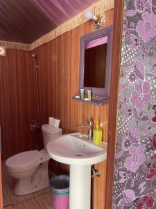 a bathroom with a sink and a toilet and a mirror at Discover the life of Wadi Rum camp in Wadi Rum +54 photos