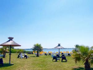 a group of chairs and umbrellas on the beach at GK - Elégance & Confort, 3ch, 2sdb, piscine, plages et campagne in Lattes