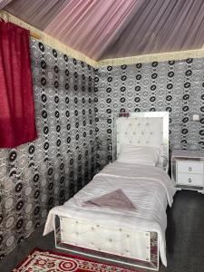 a bedroom with a bed in a room with a wall at Discover the life of Wadi Rum camp in Wadi Rum
