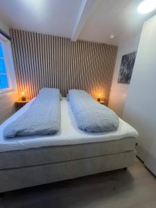een bed met twee kussens erop in een slaapkamer bij Breathe - Seafront Hideaway in Skrollsvika