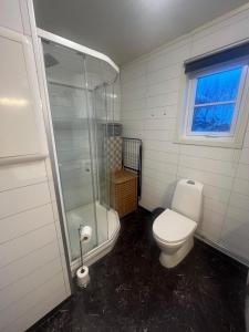 een badkamer met toilet en glazen douche bij Breathe - Seafront Hideaway in Skrollsvika +30 foto's