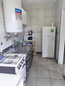 Una cocina con estufa y refrigerador blanco. en Altos Jujuy 2, en San Salvador de Jujuy