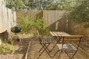 a backyard with a grill and a table and a chair at Wildlife and Ocean Cottage in Scarborough