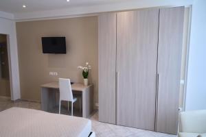 Schlafzimmer mit einem Schreibtisch, einem Bett und einem Schrank in der Unterkunft Hotel Viña del Mar Pineta in Lido di Jesolo