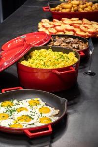 a table topped with pans of eggs and other food at Thon Hotel Verdal in Verdal +15 photos