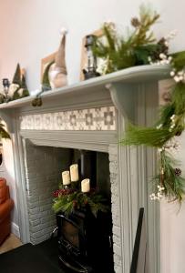 a fireplace with christmas decorations on top of it at Oranuisce Thatch Cottage Ballyvaughan in Ballyvaughan +84 photos