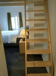 a wooden ladder in a bedroom with a bunk bed at Hotel Sternen in Gurtnellen