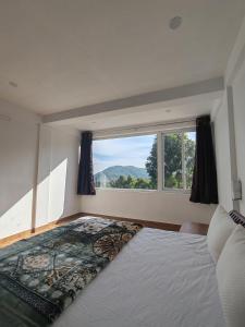 ein Schlafzimmer mit einem großen Bett mit einem großen Fenster in der Unterkunft Aden Valley, kanthalloor in Kanthalloor