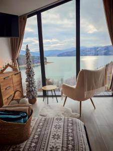 Una sala de estar con una gran vista a un lago. en Moon Lake Bicaz - Casa Oia, en Buhalniţa