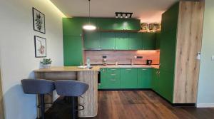 ApArt by the river في بلوفديف: مطبخ أخضر مع طاولة وبعض الكراسي