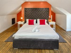 ein Schlafzimmer mit einem großen Bett mit roten Kissen in der Unterkunft Home Farm - The Dairy -Uk34626 in Dunragit