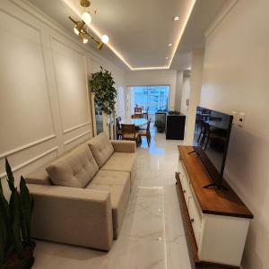 una sala de estar con un sofá y una mesa en Doce lar, en Itapema