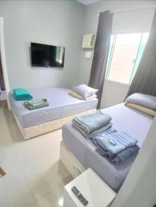 Ένα ή περισσότερα κρεβάτια σε δωμάτιο στο Casa c AR - condomínio prox ParkShopping Cpo Grande - camas de casal e solteiro