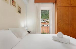 een slaapkamer met een wit bed en een raam bij Machico Bay in Machico