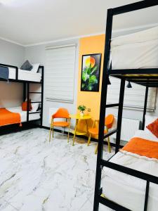 a bedroom with bunk beds and a table and chairs at Cozy Hostel in Bulgan