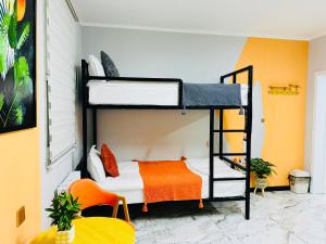 a room with two bunk beds and an orange chair at Cozy Hostel in Bulgan