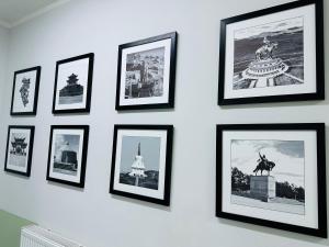 a wall with black framed pictures on a wall at Cozy Hostel in Bulgan