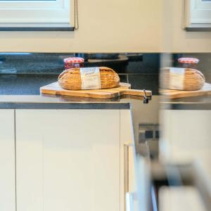 Dos hogazas de pan sobre un mostrador en una cocina. en Rowans Stow-on-the-Wold 4 Bed Cotswolds Home, en Stow on the Wold