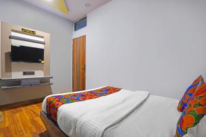 a bedroom with a bed and a television on a wall at Via Arya in Kharadi