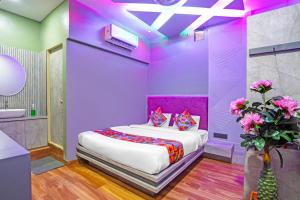 a purple bedroom with a bed and a bathroom at Via Arya in Kharadi